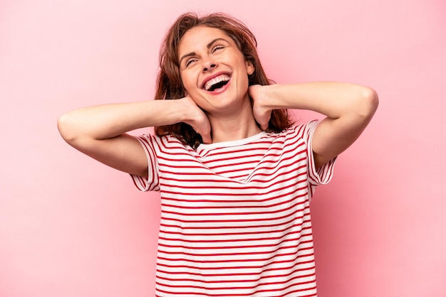 Young caucasian woman isolated on pink background feeling confident with hands behind the head