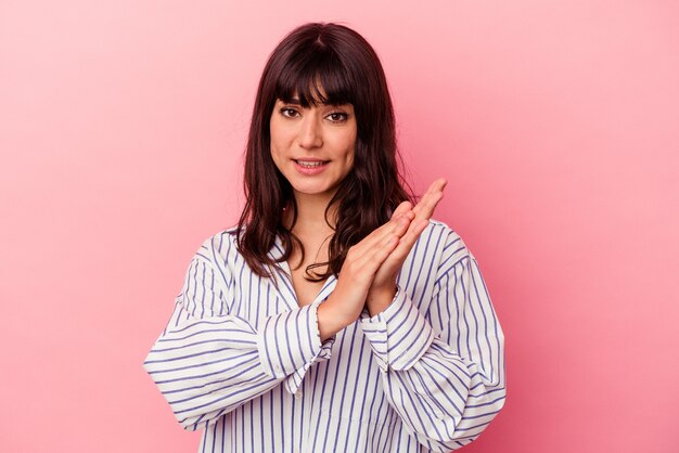 Young caucasian woman isolated on pink background feeling energetic and comfortable, rubbing hands confident.