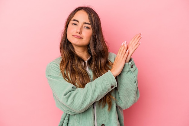 Young caucasian woman isolated on pink background feeling energetic and comfortable, rubbing hands confident.