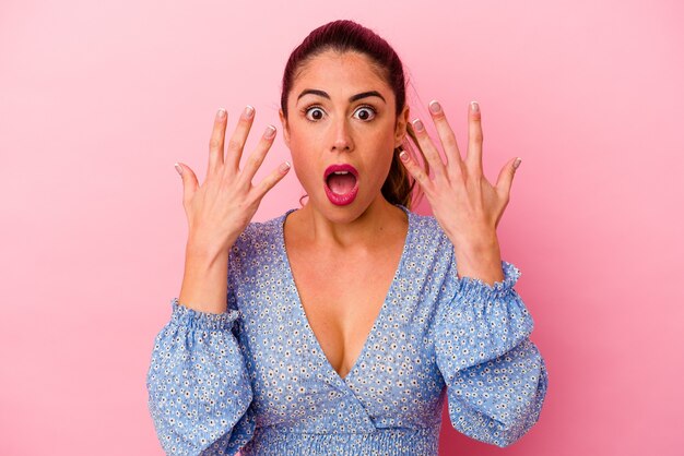 Young caucasian woman isolated on pink background feels confident giving a hug to the camera.