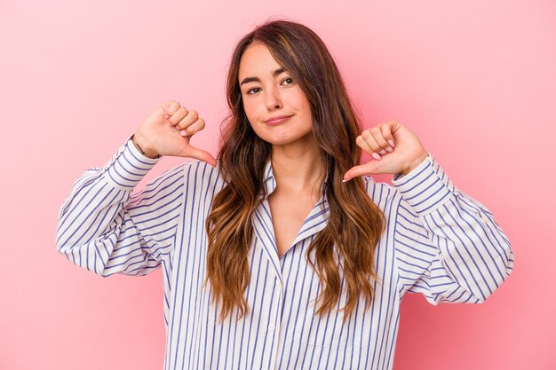 Young caucasian woman isolated on pink background feels proud and self confident, example to follow.