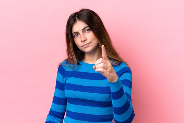 Photo young caucasian woman isolated on pink background frustrated and pointing to the front