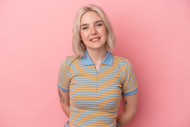 Photo young caucasian woman isolated on pink background happy, smiling and cheerful.