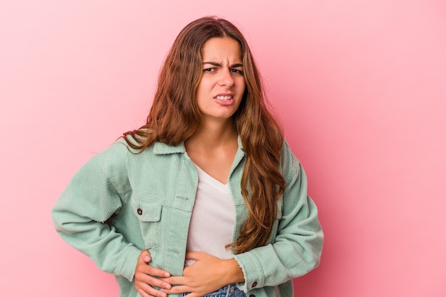 Foto giovane donna caucasica isolata su sfondo rosa con dolore al fegato, mal di stomaco.