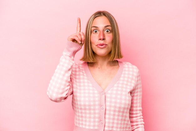 Young caucasian woman isolated on pink background having some great idea concept of creativity