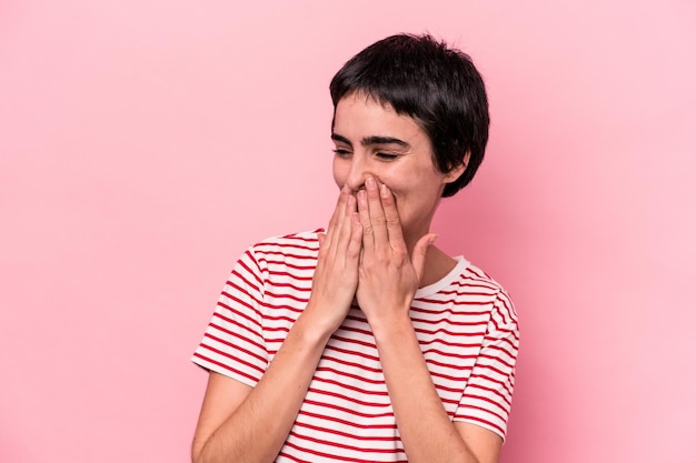 Young caucasian woman isolated on pink background laughing about something, covering mouth with hands.