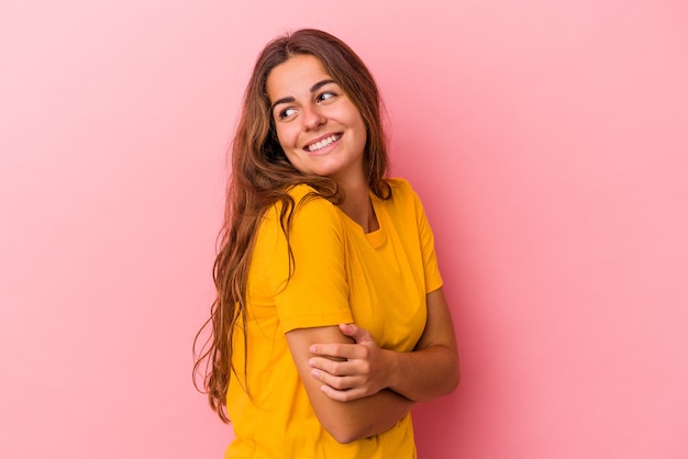 Giovane donna caucasica isolata su sfondo rosa ridendo e divertendosi.