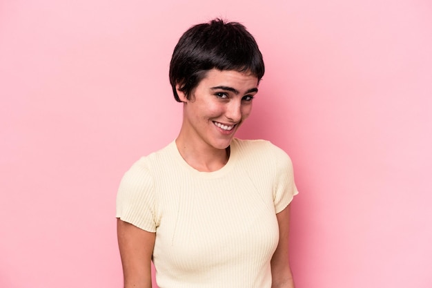 Young caucasian woman isolated on pink background laughs and closes eyes, feels relaxed and happy.