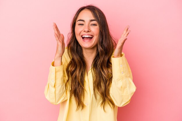 Young caucasian woman isolated on pink background laughs out loudly keeping hand on chest.