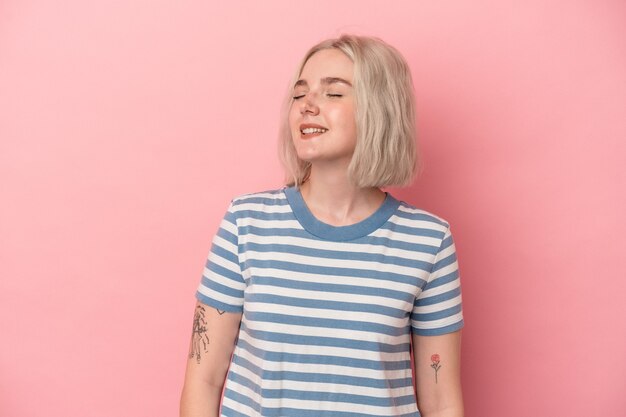 Young caucasian woman isolated on pink background relaxed and happy laughing, neck stretched showing teeth.