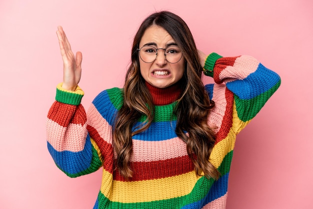 Young caucasian woman isolated on pink background screaming with rage