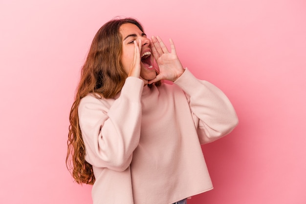 Photo young caucasian woman isolated on pink background  shouting excited to front.