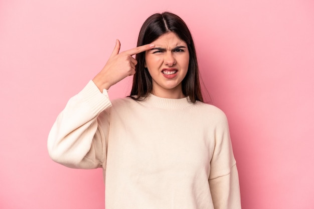 Young caucasian woman isolated on pink background showing a disappointment gesture with forefinger