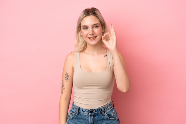 Young caucasian woman isolated on pink background showing ok sign with fingers