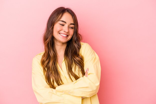 Young caucasian woman isolated on pink background smiling confident with crossed arms.