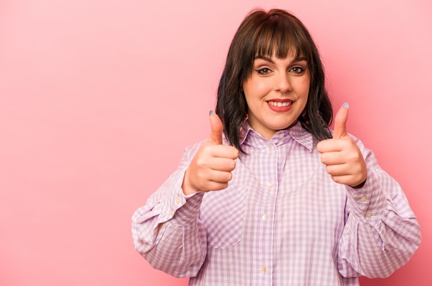 Young caucasian woman isolated on pink background smiling and raising thumb up