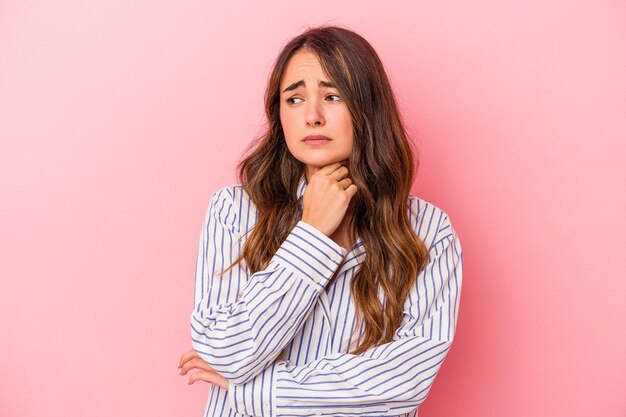 Young caucasian woman isolated on pink background suffers pain in throat due a virus or infection.