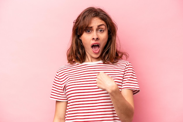 Young caucasian woman isolated on pink background surprised pointing with finger smiling broadly