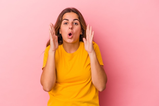 Young caucasian woman isolated on pink background  surprised and shocked.