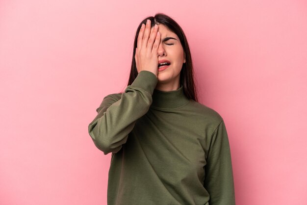 Young caucasian woman isolated on pink background tired and very sleepy keeping hand on head