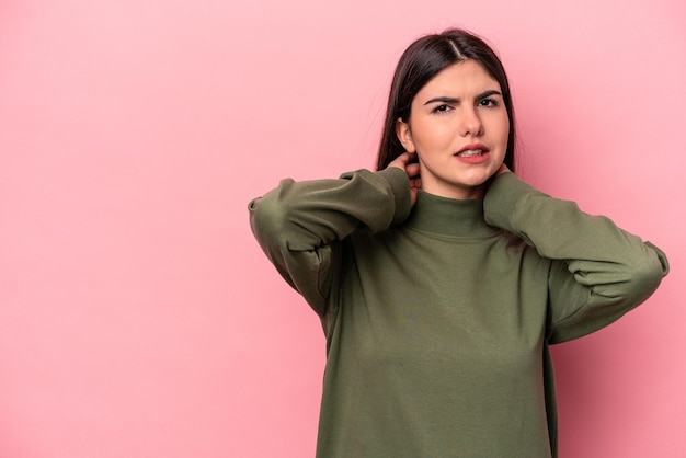 Young caucasian woman isolated on pink background touching back of head thinking and making a choice