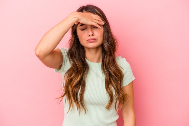 Young caucasian woman isolated on pink background touching temples and having headache.