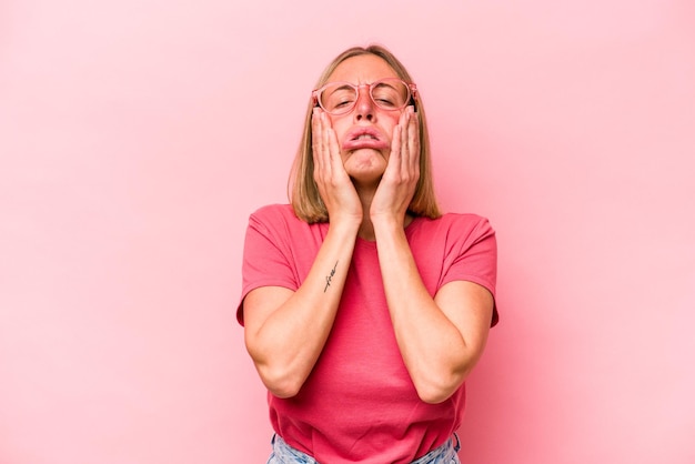 Young caucasian woman isolated on pink background whining and crying disconsolately