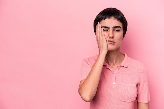 Young caucasian woman isolated on pink background who feels sad and pensive, looking at copy space.