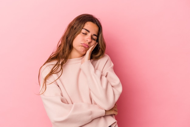 Young caucasian woman isolated on pink background  who is bored, fatigued and need a relax day.