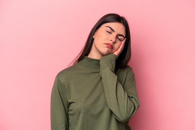 Young caucasian woman isolated on pink background who is bored fatigued and need a relax day