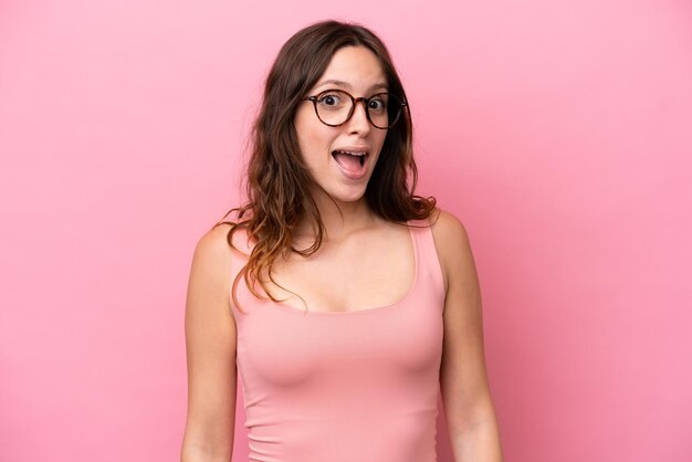 Photo young caucasian woman isolated on pink background with surprise facial expression