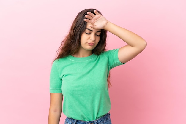 Young caucasian woman isolated on pink background with tired and sick expression