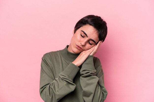 Young caucasian woman isolated on pink background yawning showing a tired gesture covering mouth with hand
