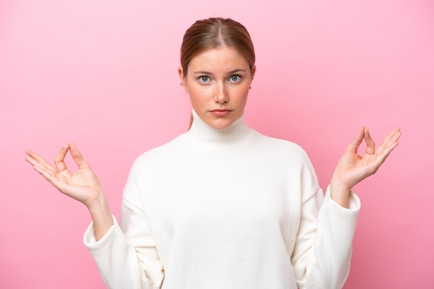 Young caucasian woman isolated on pink background in zen pose