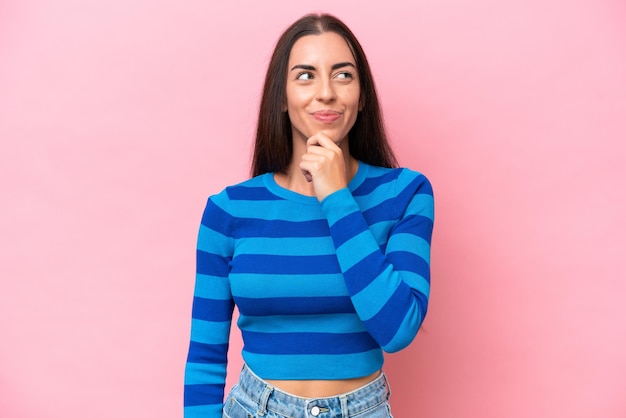 Young caucasian woman isolated on pink background