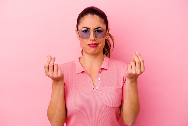 Young caucasian woman isolated on pink crossing fingers for having luck