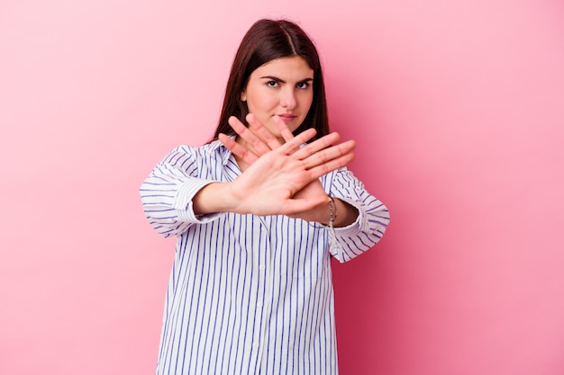 Young caucasian woman isolated on pink wall doing a denial gesture