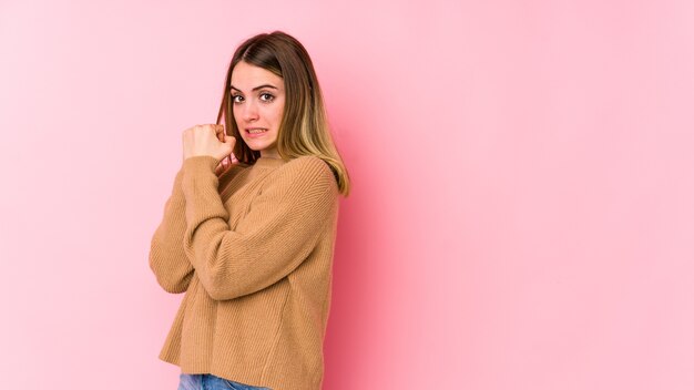 Young caucasian woman isolated on pink wall scared and afraid.