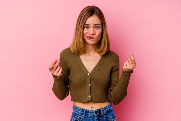 Young caucasian woman isolated on pink wall showing that she has no money