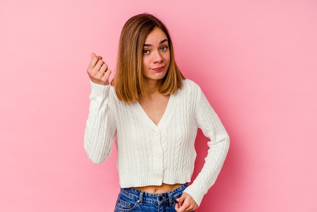 Giovane donna caucasica isolata sulla parete rosa che mostra che non ha soldi