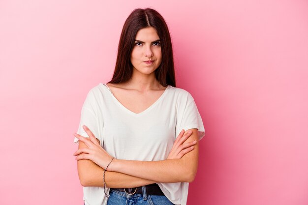 Young caucasian woman isolated on pink wall who is bored, fatigued and need a relax day.