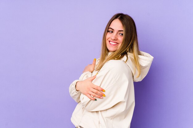 Young caucasian woman isolated on purple background laughing and having fun.