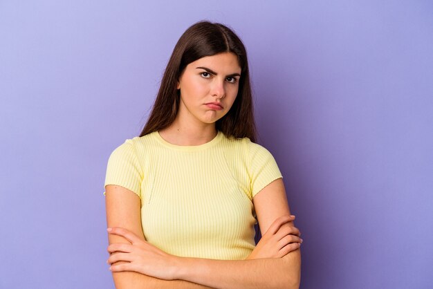 Young caucasian woman isolated on purple background who is bored, fatigued and need a relax day.