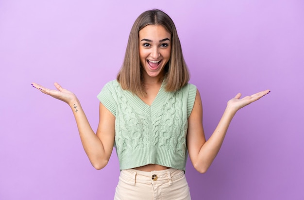 Young caucasian woman isolated on purple background with shocked facial expression