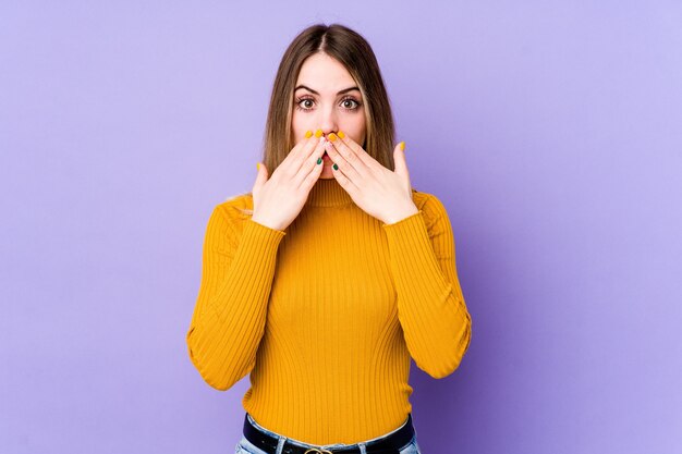 Young caucasian woman isolated on purple shocked covering mouth with hands