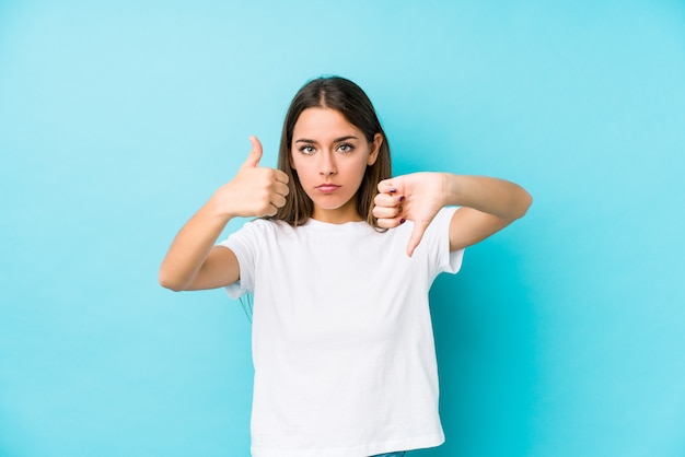 Young caucasian woman  isolated showing thumbs up and thumbs down, difficult choose concept