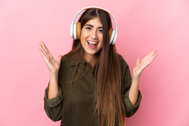 Young caucasian woman isolated surprised and listening music