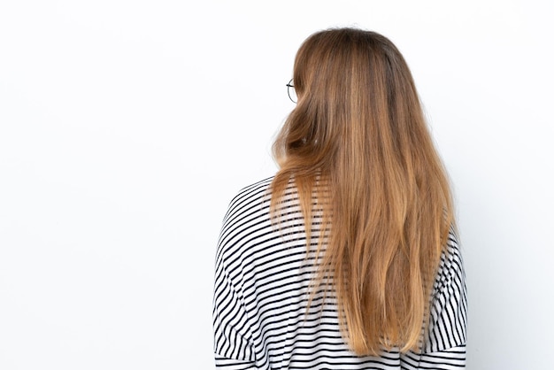 Young caucasian woman isolated on white background in back position and looking back