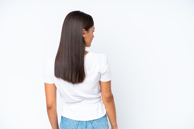 Young caucasian woman isolated on white background in back position and looking side