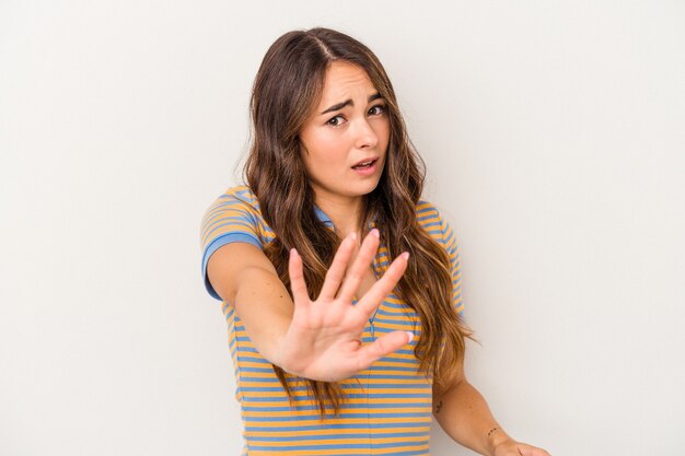 Young caucasian woman isolated on white background being shocked due to an imminent danger